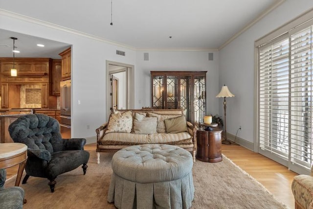 living area with light wood-type flooring and ornamental molding