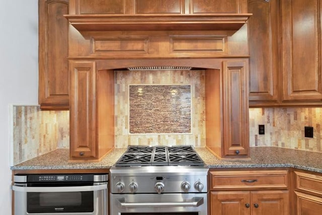 kitchen featuring appliances with stainless steel finishes, backsplash, and stone countertops