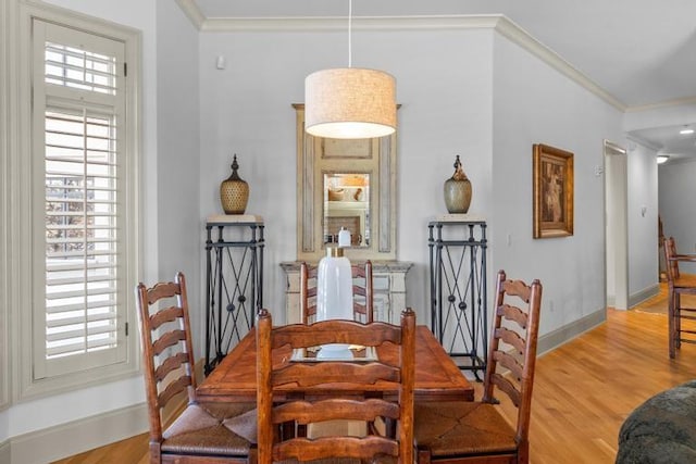 dining area with light hardwood / wood-style floors and crown molding