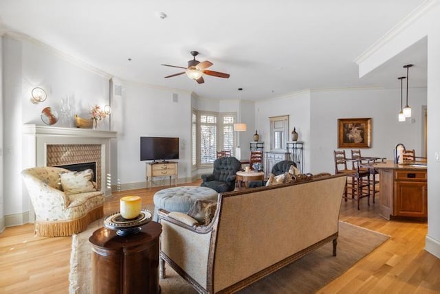 living room with ceiling fan, light hardwood / wood-style flooring, sink, and ornamental molding