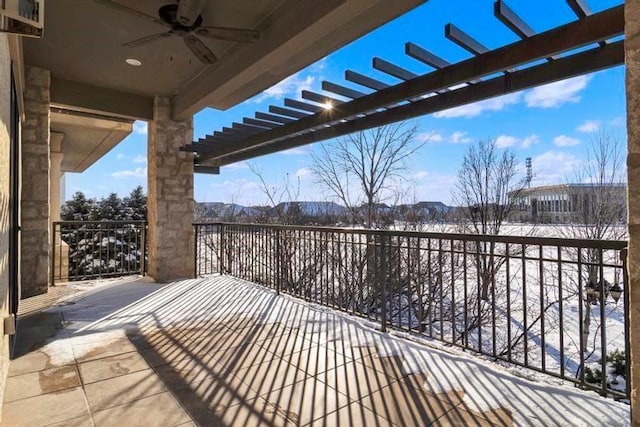 snow covered patio with a mountain view, a pergola, a balcony, and ceiling fan