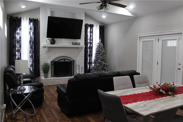 dining room with ceiling fan, a fireplace, dark hardwood / wood-style floors, plenty of natural light, and lofted ceiling