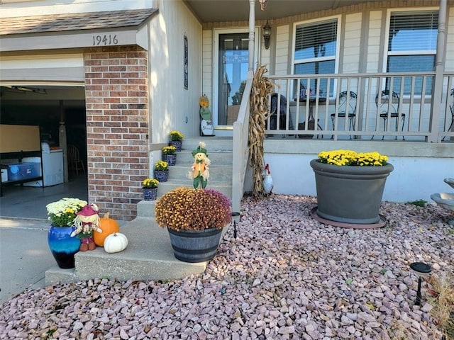 view of exterior entry featuring a garage and covered porch