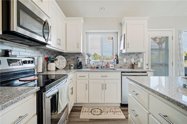 kitchen featuring sink, white cabinetry, stainless steel appliances, and tasteful backsplash