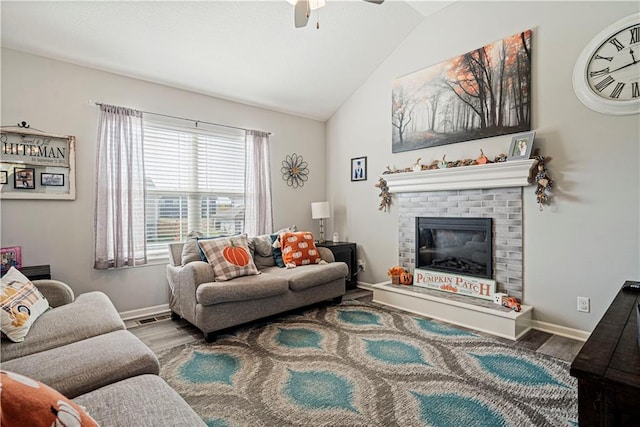 living room featuring a brick fireplace, ceiling fan, vaulted ceiling, and hardwood / wood-style flooring