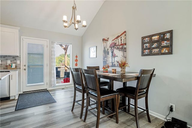 dining area featuring lofted ceiling, dark wood-type flooring, and an inviting chandelier