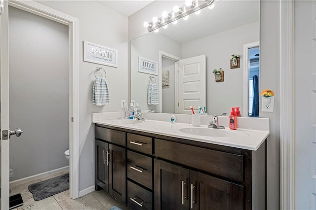 bathroom with tile patterned flooring, vanity, and toilet