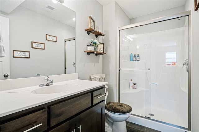 bathroom featuring tile patterned floors, vanity, an enclosed shower, and toilet