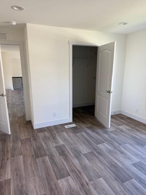 unfurnished bedroom featuring a closet and dark hardwood / wood-style floors