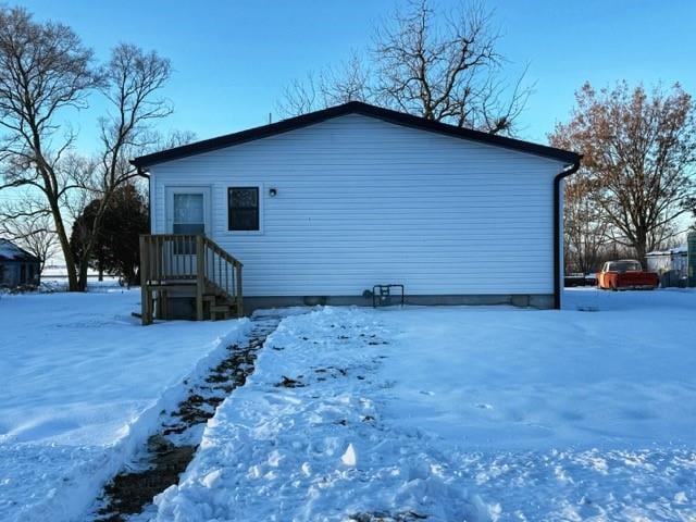 view of snow covered back of property