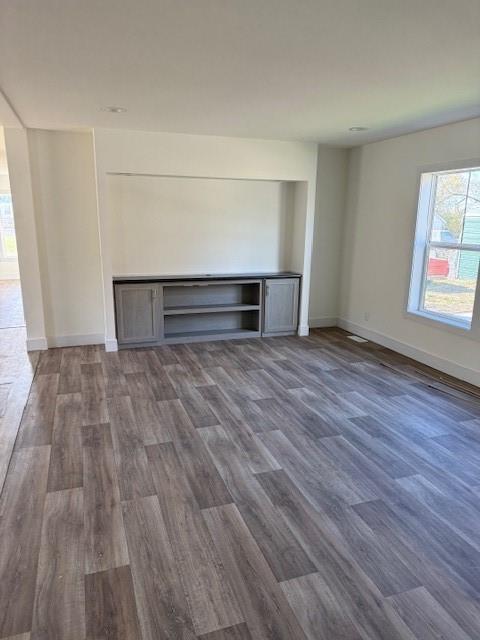 unfurnished living room featuring dark hardwood / wood-style floors