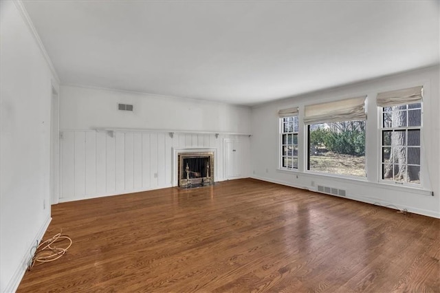 unfurnished living room with visible vents, a fireplace with flush hearth, and wood finished floors