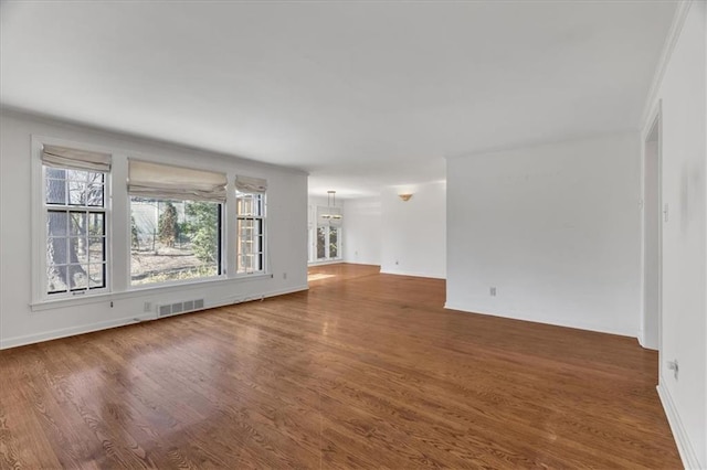 spare room featuring wood finished floors and visible vents