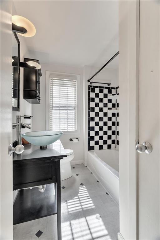 full bath featuring vanity, tile patterned floors, toilet, and washtub / shower combination