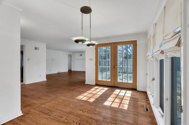 unfurnished dining area with french doors, baseboards, visible vents, and wood finished floors