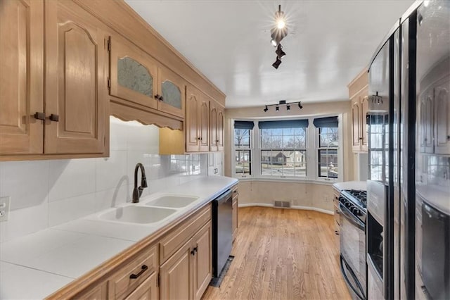 kitchen featuring visible vents, black gas range, dishwasher, refrigerator with ice dispenser, and a sink