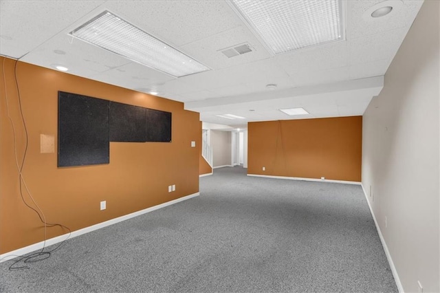 empty room with visible vents, baseboards, carpet, and a drop ceiling