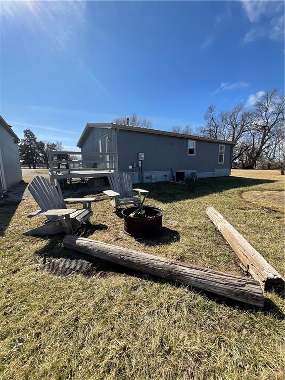 rear view of house featuring cooling unit and a lawn