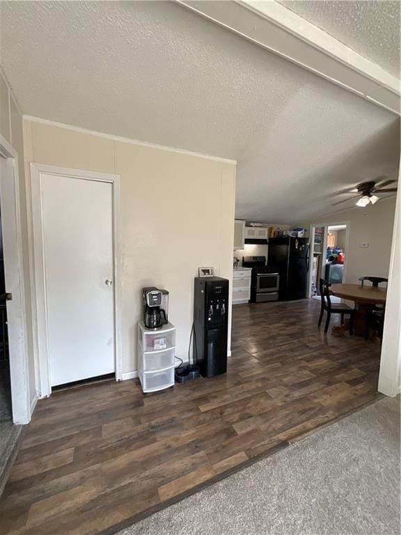 kitchen featuring freestanding refrigerator, stainless steel range with electric cooktop, a textured ceiling, and wood finished floors