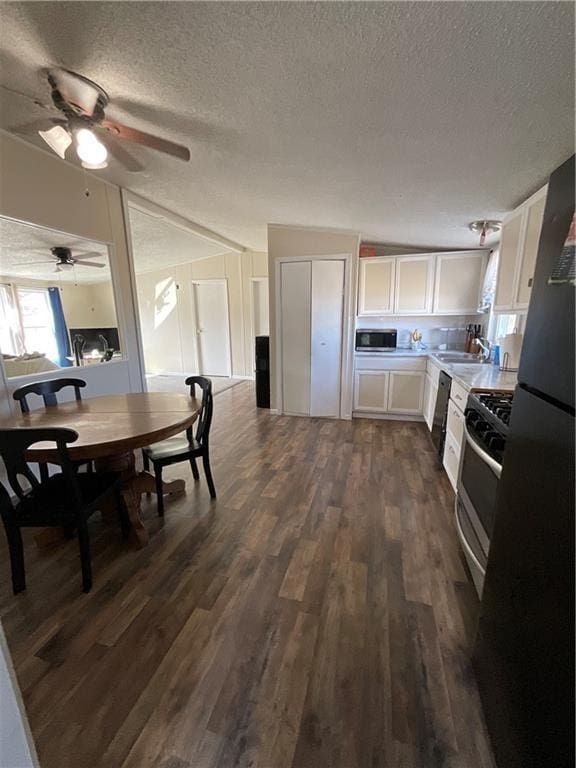 kitchen featuring stainless steel appliances, dark wood-type flooring, light countertops, and white cabinets