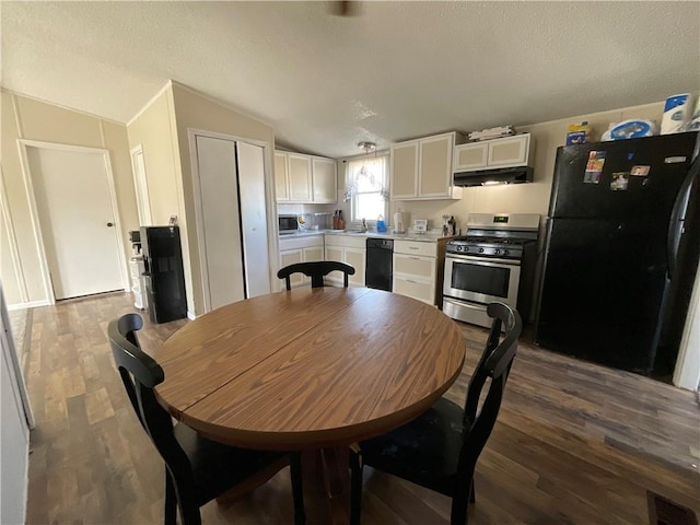 dining room with lofted ceiling, dark wood-style floors, visible vents, and a textured ceiling