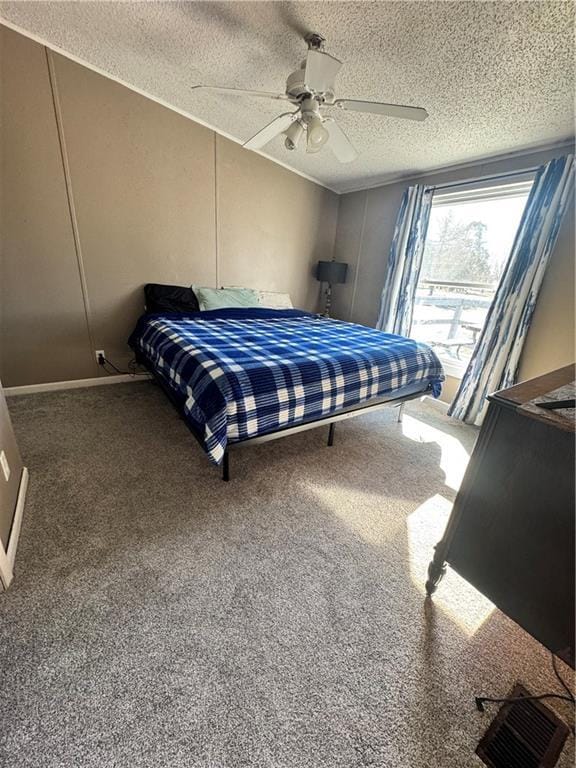 carpeted bedroom featuring a textured ceiling and a ceiling fan