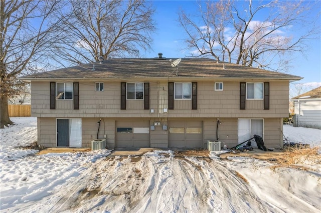 raised ranch with central air condition unit and a garage