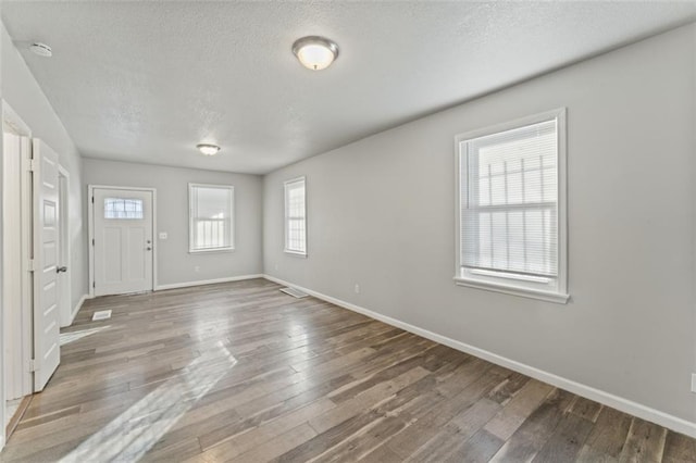 foyer entrance with hardwood / wood-style floors and a textured ceiling