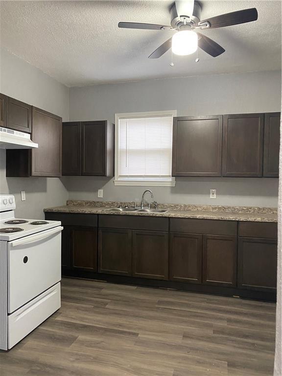 kitchen featuring sink, ceiling fan, a textured ceiling, white electric range oven, and dark brown cabinets