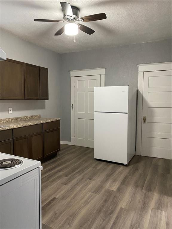 kitchen featuring a textured ceiling, white appliances, dark hardwood / wood-style floors, and dark brown cabinets