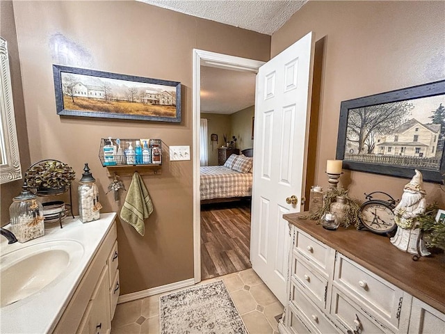 bathroom featuring tile patterned floors, vanity, and a textured ceiling