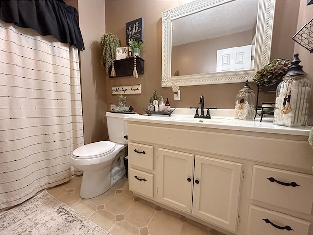 bathroom with tile patterned flooring, vanity, and toilet