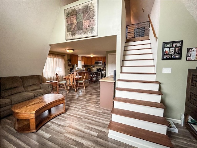 stairs featuring wood-type flooring and a high ceiling