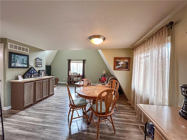 dining area with a textured ceiling and light wood-type flooring