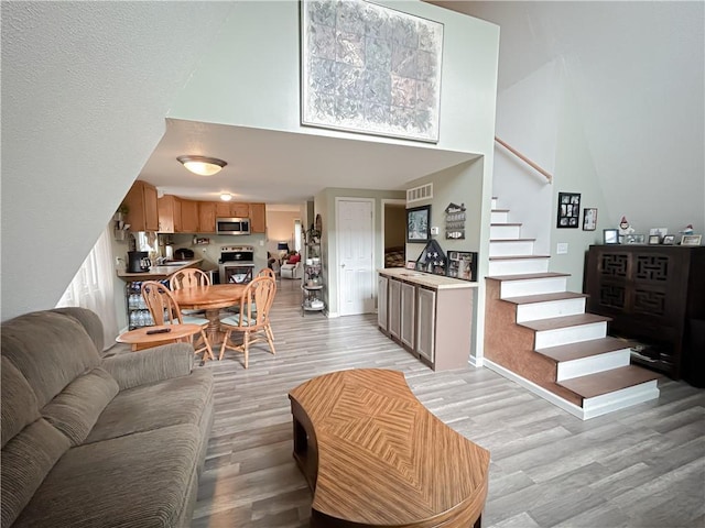 living room with a high ceiling and light wood-type flooring