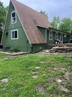 17 Lakewood Ln, Linn Valley, KS 66040 - back of property featuring a lawn, a shingled roof, and a wooden deck