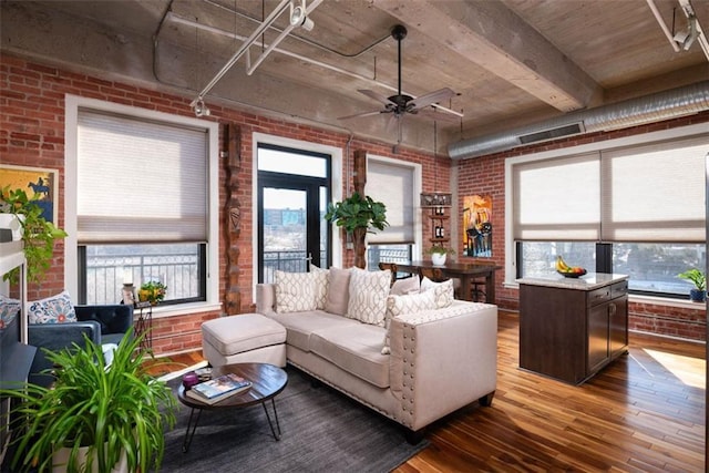 living room featuring ceiling fan, brick wall, and dark hardwood / wood-style flooring