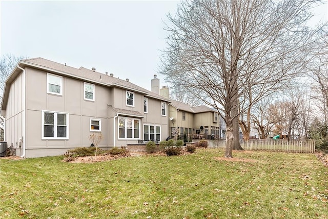 back of house featuring central AC and a lawn