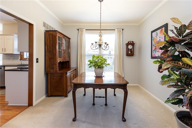 dining area with ornamental molding, a chandelier, sink, and light carpet