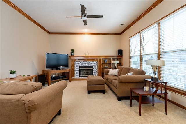 living room featuring crown molding, light colored carpet, a tile fireplace, and ceiling fan