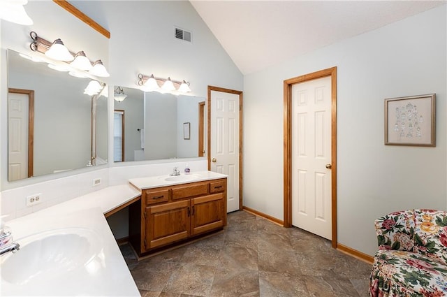 bathroom with vanity and high vaulted ceiling