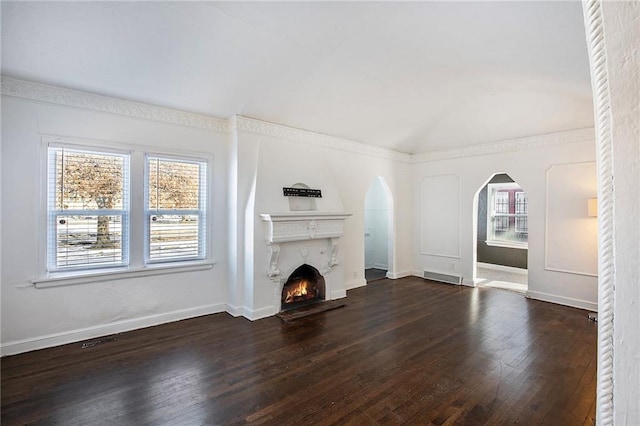 unfurnished living room featuring ornamental molding and dark wood-type flooring