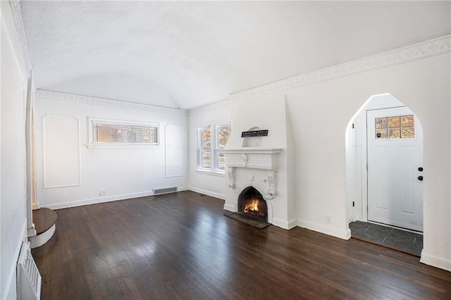 unfurnished living room with brick ceiling, vaulted ceiling, and dark hardwood / wood-style floors