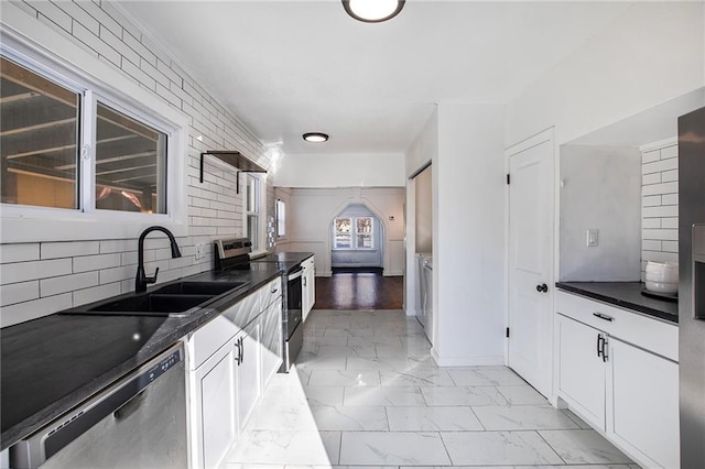 kitchen with sink, white cabinetry, tasteful backsplash, and appliances with stainless steel finishes