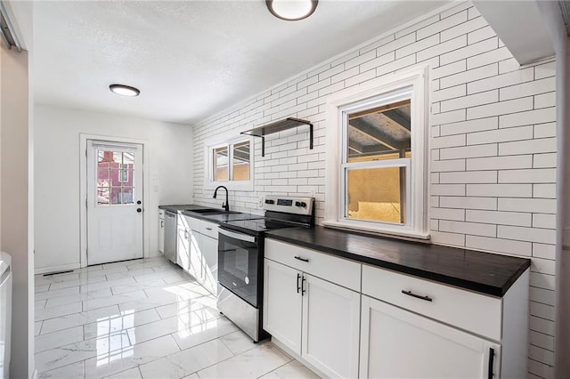 kitchen featuring appliances with stainless steel finishes, white cabinetry, and sink