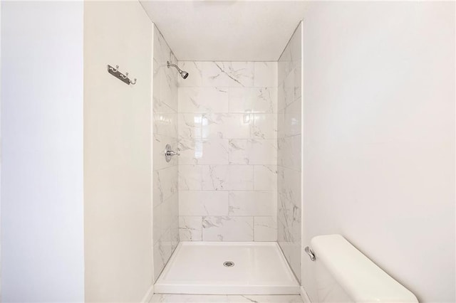 bathroom with toilet and a tile shower