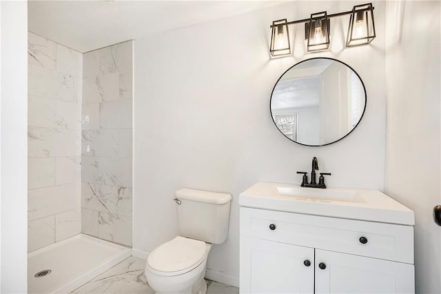 bathroom with a tile shower, vanity, and toilet