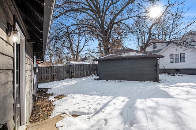 yard layered in snow featuring a storage unit