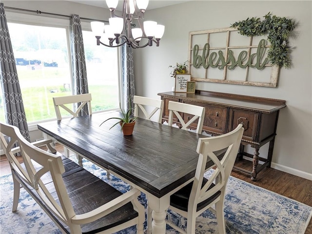 dining space with dark hardwood / wood-style floors and a notable chandelier