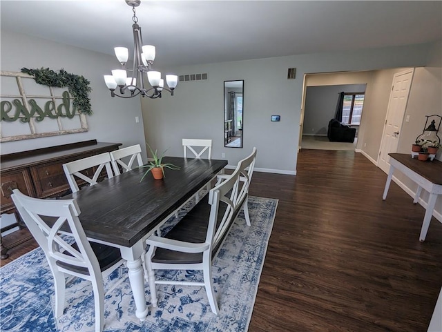 dining space with dark hardwood / wood-style flooring and a chandelier